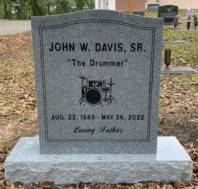 granite headstone with a drum set emblem